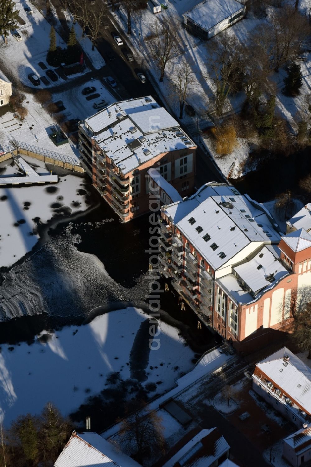 Brandenburg an der Havel from above - Winterly snowy historical building Burgmuehle in Brandenburg an der Havel in the state Brandenburg over the course of the river Domstreng with condominiums, assisted living and holiday apartments