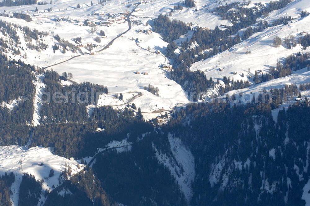 SEIS from the bird's eye view: Winterlich verschneite Seiser Alm mit dem Schlern Gebirgsmassiv der Dolomiten. Der Schlern (2.563 m, ital. Sciliar) ist ein Berg in den Dolomiten/Alpen in Südtirol, Italien. Trotz seiner geringen Höhe gilt er u.a. auf Grund seiner charakteristischen Form mit den beiden vorgelagerten Bergspitzen, der Santner- (2.413 m s.l.m.) und der Euringerspitze (2.394 m s.l.m.), als Wahrzeichen Südtirols. An den Schlern angelehnt ist die Seiser Alm, die höchstgelegene Hochweide Europas. 1974 wurde das umgebende Gebiet zum Naturpark erklärt, heute Teil des Naturparks Schlern-Rosengarten.Das Schlern-Massiv entstand wie die übrigen Berge der Dolomiten gegen Ende des Erdaltertums, in der sog. Permzeit. In der Tethys, die damals diese Landmassen bedeckte, sanken während einer langen Zeitspanne Ablagerungen von kleinen kalkhaltigen Tieren auf den Grund. Temperatur- und Lichtverhältnisse waren wahrscheinlich die Ursache, dass sich Korallenriffe ansiedelten. So bauten sich im Lauf von Jahrmillionen riesige Korallenbauten von tausenden Metern auf. Druck verdichtete langsam das Kalkgebilde. Durch Absinken der darunter liegenden Bozner Quarzporphyrplatte bildete sich die typische Form des Schlerns. Dann, zu Beginn des Erdmittelalters, erhob sich das Gebiet aus der Tethys. Die Afrikanische Platte schob sich langsam unter die Eurasische Platte und die Alpen falteten sich auf. Durch Erosion erlangte der Schlern schließlich sein heutiges Gesicht.