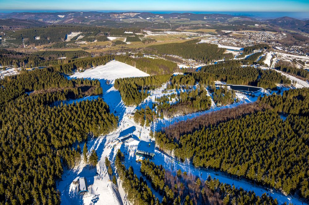 Winterberg from the bird's eye view: Wintry snowy mountain slope with downhill ski slope and cable car - lift on Bremberg in Winterberg at Sauerland in the state North Rhine-Westphalia, Germany