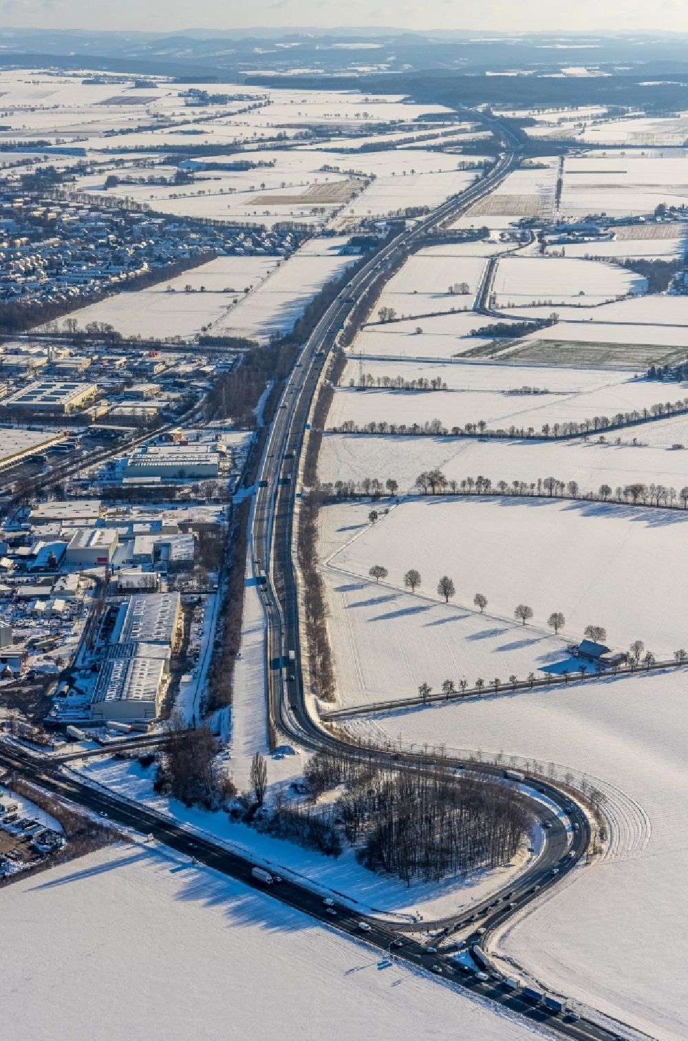 Werl from the bird's eye view: Wintry snowy route and lanes in the course of the exit and access of the motorway junction of the BAB A445 on Bundesstrasse B63 am Industriegebiet on Hammer Strasse in Werl at Ruhrgebiet in the state North Rhine-Westphalia, Germany