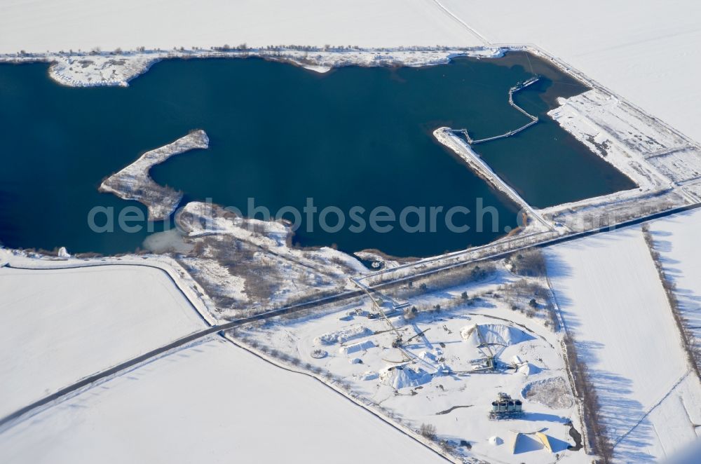 Aerial image Halberstadt - Wintry snowy lake shore and overburden areas of the quarry lake and gravel open pit Kiessee Wegeleben in Halberstadt in the state Saxony-Anhalt, Germany