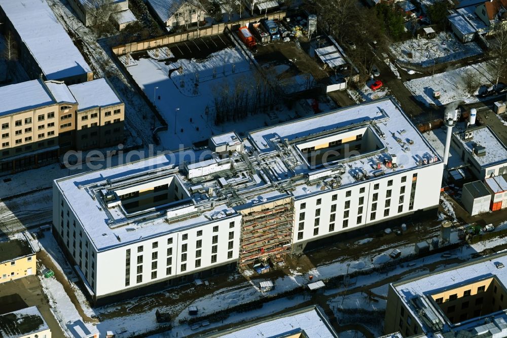 Aerial image Berlin - Wintry snowy construction site of a new build retirement home of Vivantes Forum fuer Senioren GmbH on Muensterberger Weg in the district Kaulsdorf in Berlin, Germany