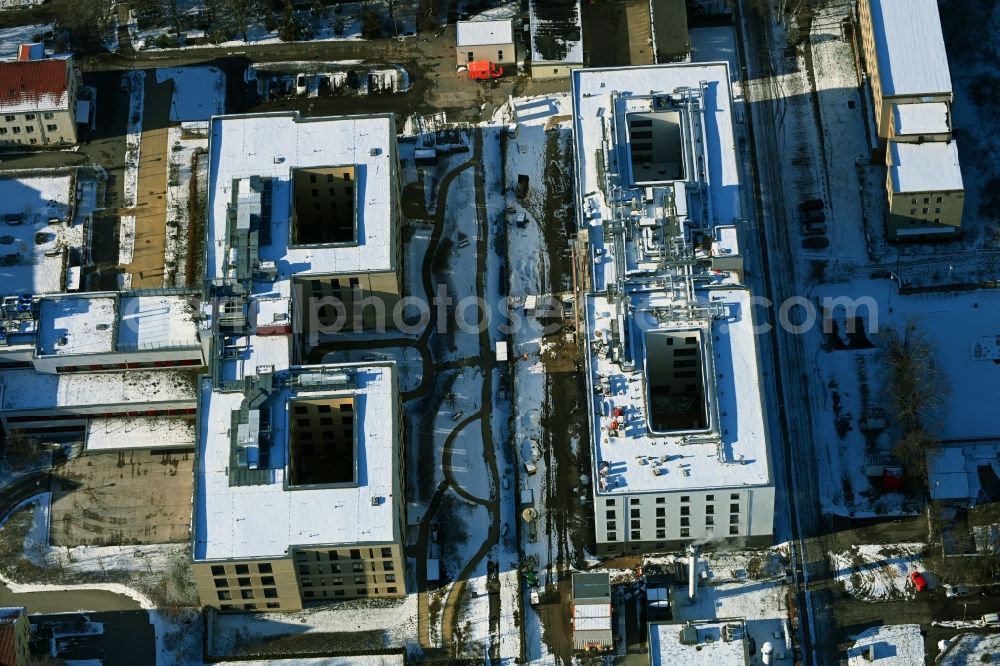 Aerial image Berlin - Wintry snowy construction site of a new build retirement home of Vivantes Forum fuer Senioren GmbH on Muensterberger Weg in the district Kaulsdorf in Berlin, Germany