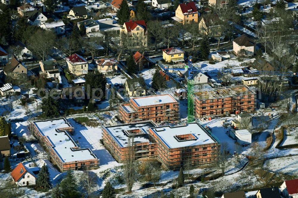Aerial image Berlin - Wintry snowy construction site of a new build retirement home on Wernergraben corner Sudermannstrasse in the district Mahlsdorf in Berlin, Germany