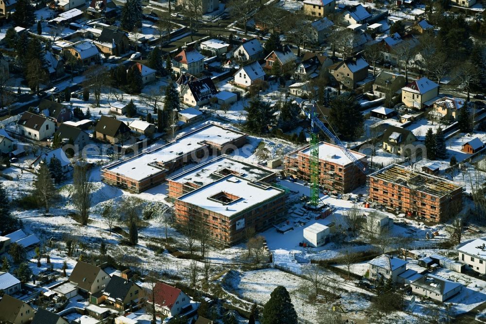Aerial photograph Berlin - Wintry snowy construction site of a new build retirement home on Wernergraben corner Sudermannstrasse in the district Mahlsdorf in Berlin, Germany