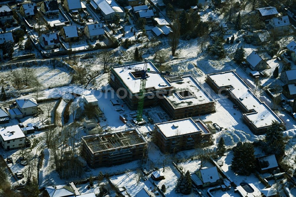 Aerial photograph Berlin - Wintry snowy construction site of a new build retirement home on Wernergraben corner Sudermannstrasse in the district Mahlsdorf in Berlin, Germany