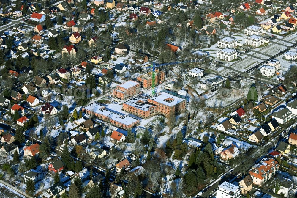 Berlin from the bird's eye view: Wintry snowy construction site of a new build retirement home on Wernergraben corner Sudermannstrasse in the district Mahlsdorf in Berlin, Germany