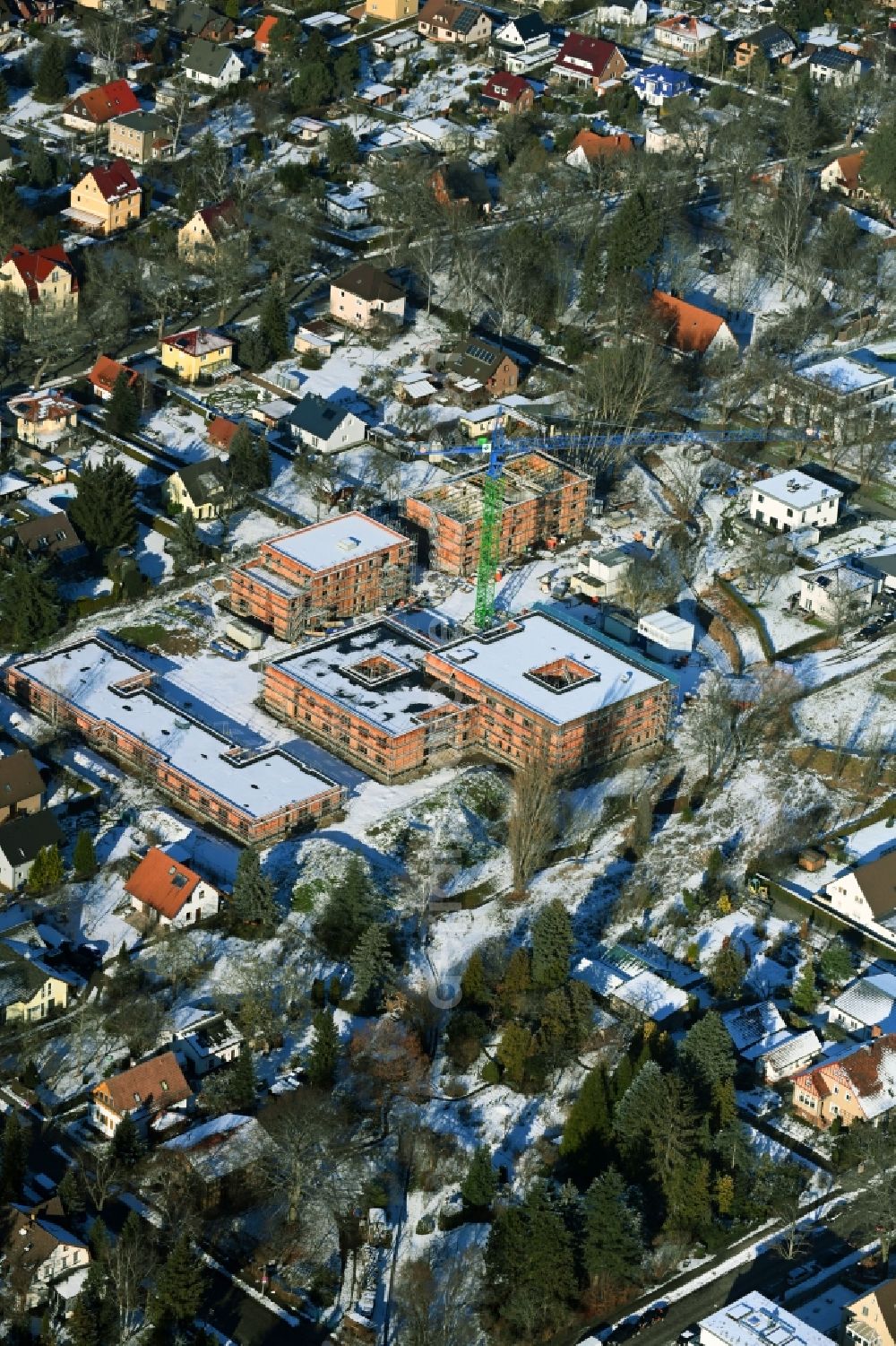 Aerial image Berlin - Wintry snowy construction site of a new build retirement home on Wernergraben corner Sudermannstrasse in the district Mahlsdorf in Berlin, Germany