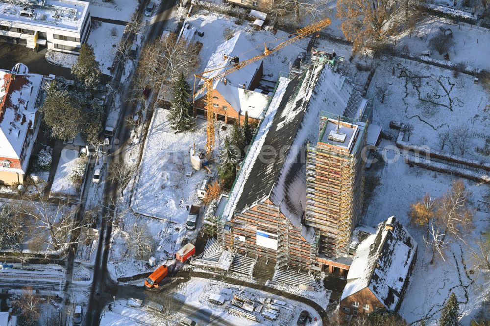 Berlin from the bird's eye view: Wintry snowy construction site for renovation and reconstruction work on the church building Jesus-Christus-Kirche on street Hittorfstrasse on street Hittorfstrasse in the district Dahlem in Berlin, Germany