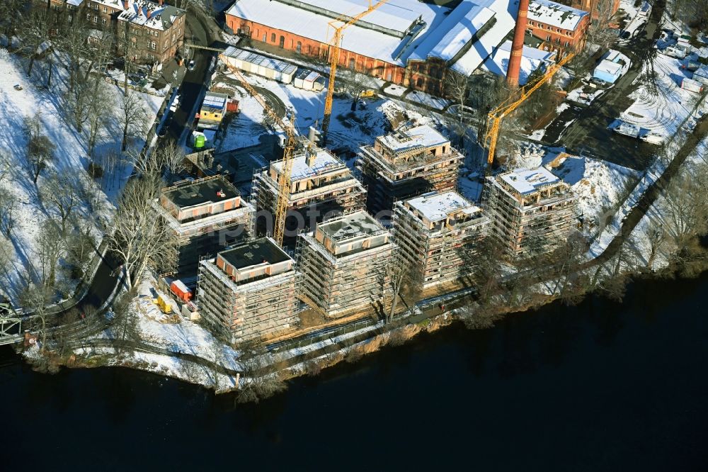 Berlin from the bird's eye view: Wintry snowy construction site for the construction of an apartment building on the Havel island of Eiswerder in the district of Hakenfelde in Berlin, Germany