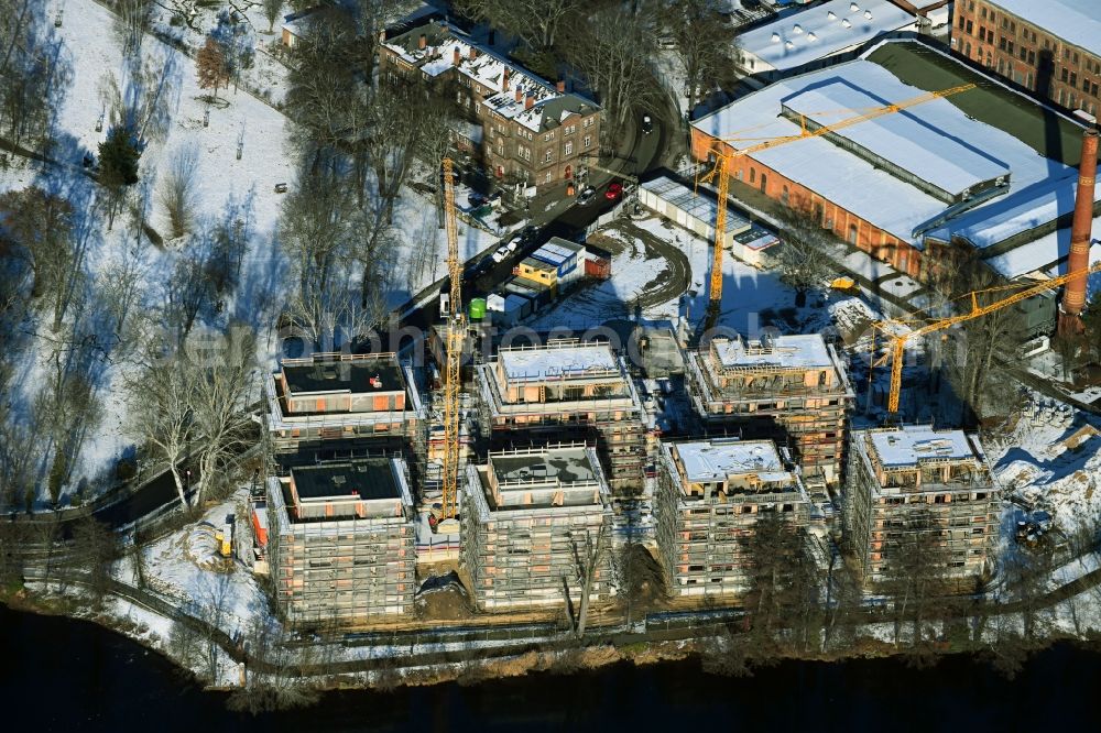 Aerial image Berlin - Wintry snowy construction site for the construction of an apartment building on the Havel island of Eiswerder in the district of Hakenfelde in Berlin, Germany