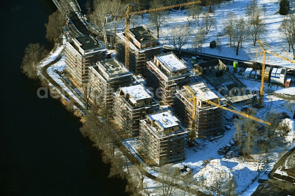 Berlin from the bird's eye view: Wintry snowy construction site for the construction of an apartment building on the Havel island of Eiswerder in the district of Hakenfelde in Berlin, Germany