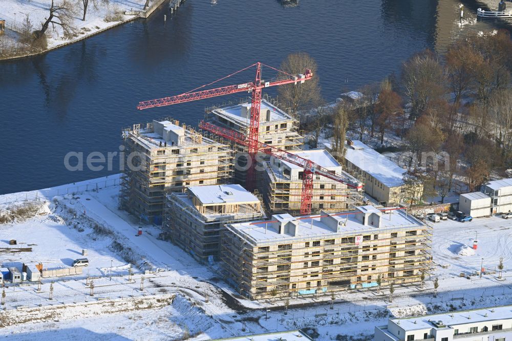 Berlin from the bird's eye view: Wintry snowy construction site to build a new multi-family residential complex Fliessstrasse - Hasselwerder Strasse on river Spree in the district Schoeneweide in Berlin, Germany