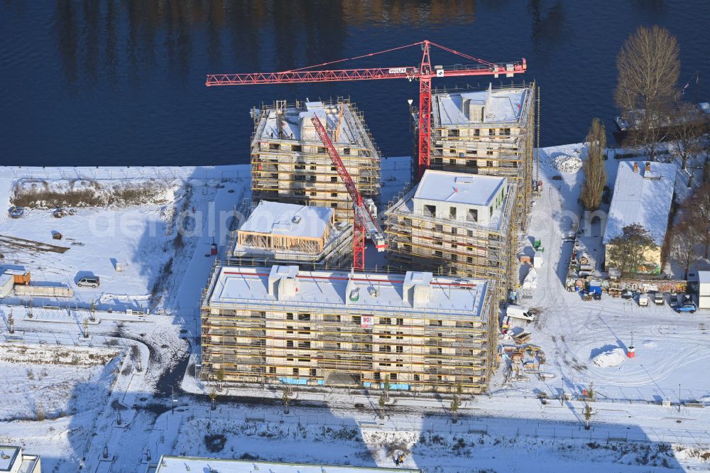 Aerial photograph Berlin - Wintry snowy construction site to build a new multi-family residential complex Fliessstrasse - Hasselwerder Strasse on river Spree in the district Schoeneweide in Berlin, Germany
