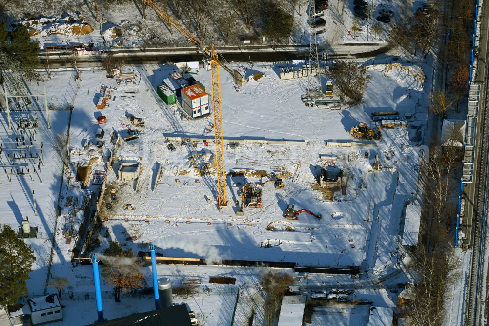 Bernau from the bird's eye view: Wintry snowy Construction site for the new parking garage bevore train station on Lenastrasse on street Angarastrasse in the district Friedenstal in Bernau in the state Brandenburg, Germany