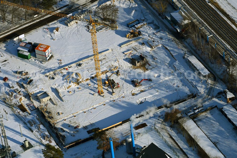Aerial photograph Bernau - Wintry snowy Construction site for the new parking garage bevore train station on Lenastrasse on street Angarastrasse in the district Friedenstal in Bernau in the state Brandenburg, Germany