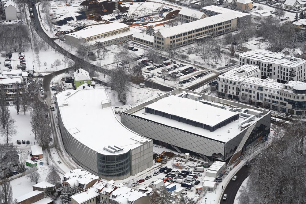 Aerial image Bernau - Wintry snowy construction site for the new parking garage and Mehrzweckhalle on Ladeburger Chaussee - Jahnstrasse - Ladeburger Strasse in Bernau in the state Brandenburg, Germany