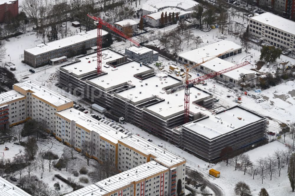 Berlin from above - Wintry snowy new construction site of the school building Gymnasium with Sporthalle on street Erich-Kaestner-Strasse - Peter-Huchel-Strasse in the district Hellersdorf in Berlin, Germany
