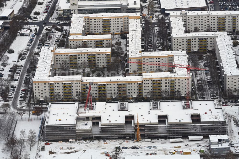 Berlin from the bird's eye view: Wintry snowy new construction site of the school building Gymnasium with Sporthalle on street Erich-Kaestner-Strasse - Peter-Huchel-Strasse in the district Hellersdorf in Berlin, Germany