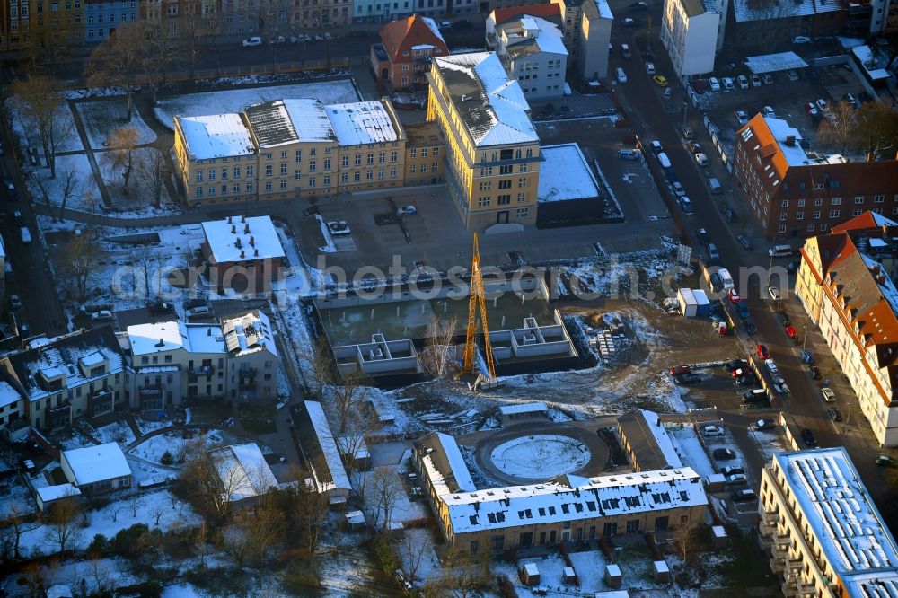 Schwerin from the bird's eye view: Wintry snowy construction site for the city villa - multi-family residential building on Robert-Koch-Strasse in Schwerin in the state Mecklenburg - Western Pomerania, Germany