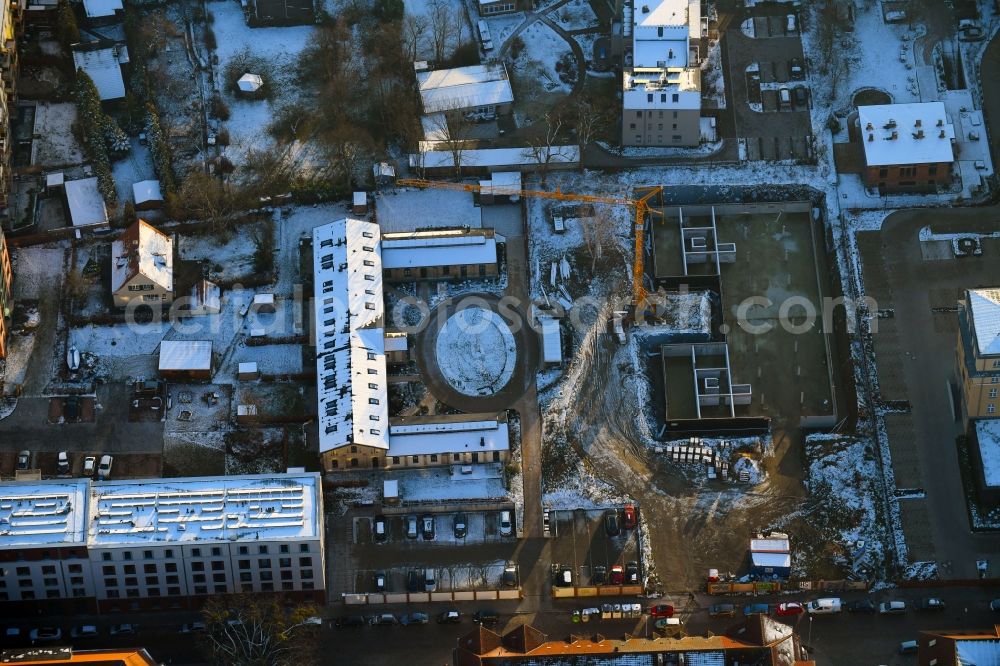 Aerial photograph Schwerin - Wintry snowy construction site for the city villa - multi-family residential building on Robert-Koch-Strasse in Schwerin in the state Mecklenburg - Western Pomerania, Germany