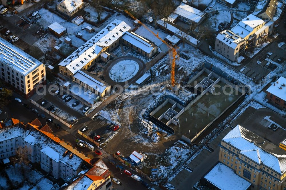 Schwerin from above - Wintry snowy construction site for the city villa - multi-family residential building on Robert-Koch-Strasse in Schwerin in the state Mecklenburg - Western Pomerania, Germany