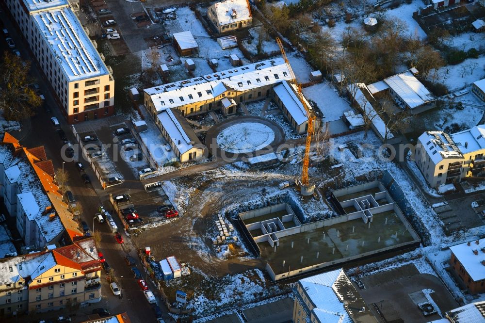 Schwerin from the bird's eye view: Wintry snowy construction site for the city villa - multi-family residential building on Robert-Koch-Strasse in Schwerin in the state Mecklenburg - Western Pomerania, Germany