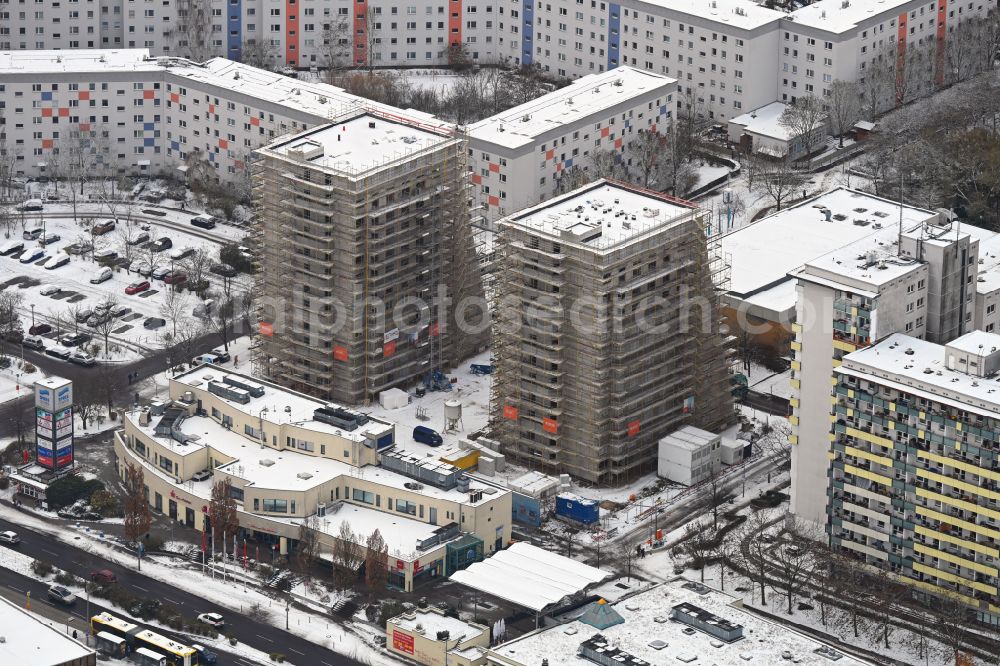 Aerial image Berlin - Wintry snowy construction site for the multi-family residential building on Ludwigsluster Strasse on street Teterower Ring in the district Hellersdorf in Berlin, Germany