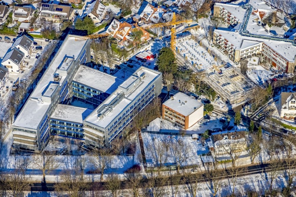 Mülheim an der Ruhr from the bird's eye view: Wintry snowy construction site for the multi-family residential building next to the administration building of the company T-Systems International GmbH on Parsevalstrasse in the district Flughafensiedlung in Muelheim on the Ruhr at Ruhrgebiet in the state North Rhine-Westphalia, Germany
