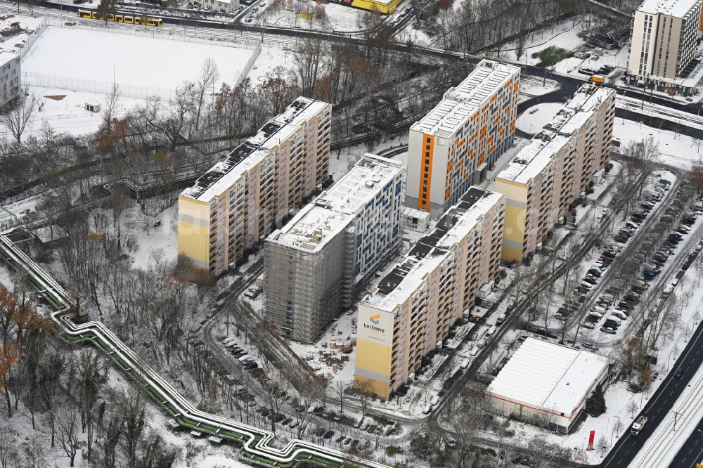 Berlin from the bird's eye view: Wintry snowy construction site for the multi-family residential building with Studentenapartments of Belinovo Grundstuecksentwicklung GmbH on street Rhinstrasse in the district Friedrichsfelde in Berlin, Germany