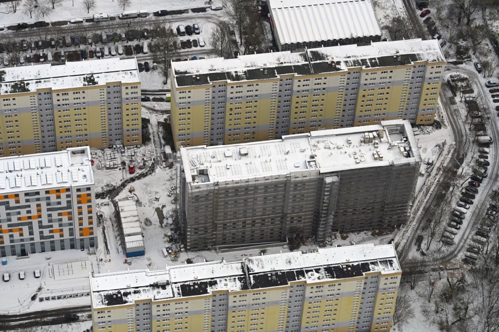 Berlin from above - Wintry snowy construction site for the multi-family residential building with Studentenapartments of Belinovo Grundstuecksentwicklung GmbH on street Rhinstrasse in the district Friedrichsfelde in Berlin, Germany