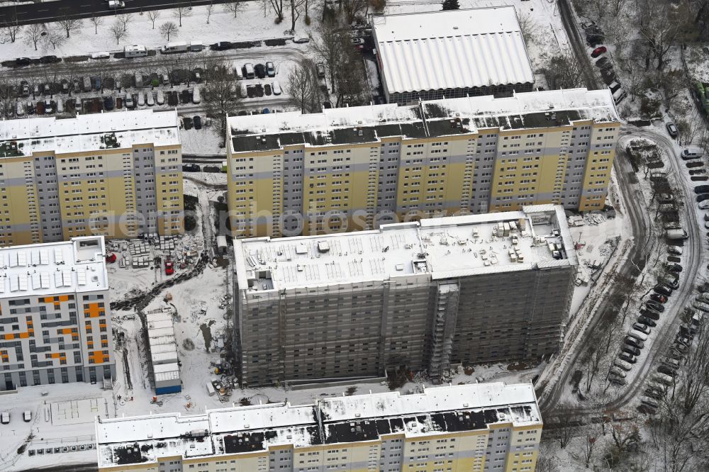 Berlin from the bird's eye view: Wintry snowy construction site for the multi-family residential building with Studentenapartments of Belinovo Grundstuecksentwicklung GmbH on street Rhinstrasse in the district Friedrichsfelde in Berlin, Germany