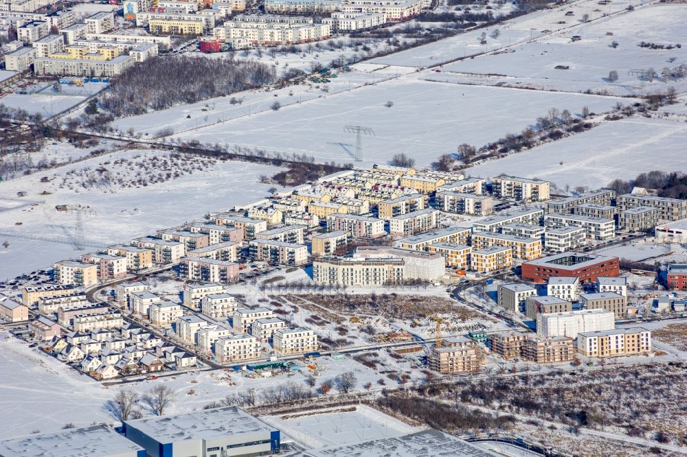 Schönefeld from the bird's eye view: Wintry snowy construction site for the multi-family residential building Theodor-Fontane-Hoefe on Theodor-Fontane-Allee - Bayangolpark in Schoenefeld in the state Brandenburg, Germany