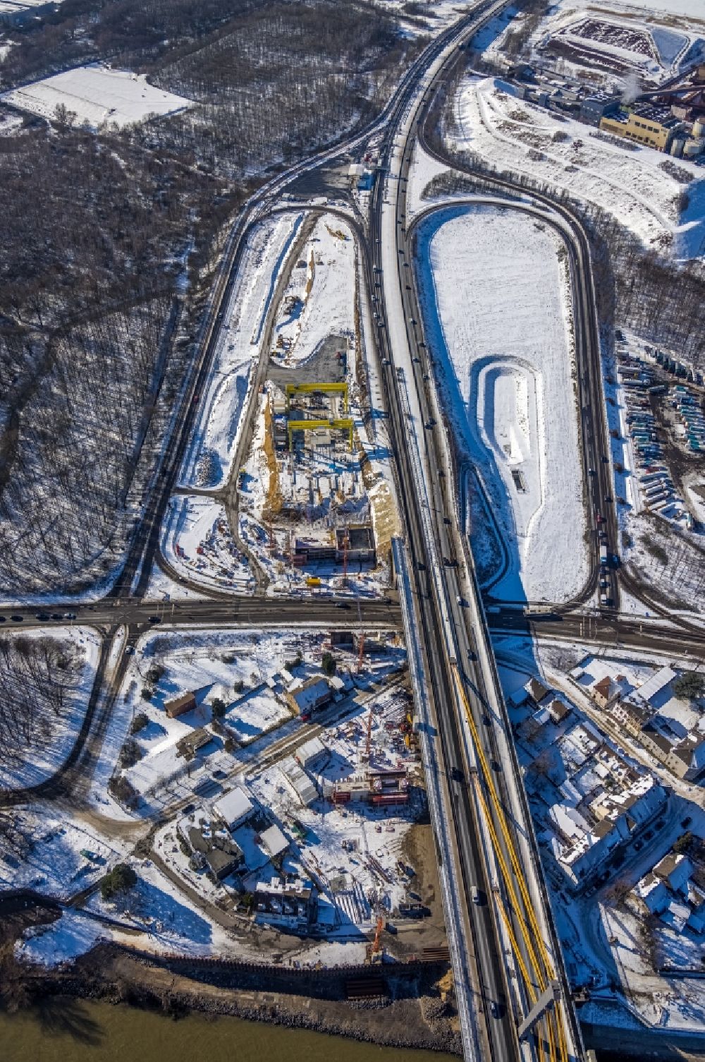 Duisburg from the bird's eye view: Wintry snowy construction site for the rehabilitation and repair of the motorway bridge construction Rheinbruecke Duisburg-Neuenkamp in the district Kasslerfeld in Duisburg at Ruhrgebiet in the state North Rhine-Westphalia, Germany