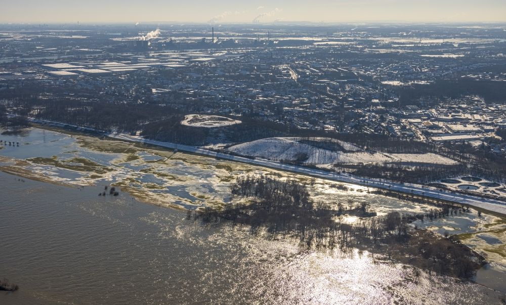 Duisburg from the bird's eye view: Wintry snowy riparian areas and flooded flood meadows due to a river bed leading to flood levels of the Rhine river in the district Bergheim in Duisburg at Ruhrgebiet in the state North Rhine-Westphalia, Germany