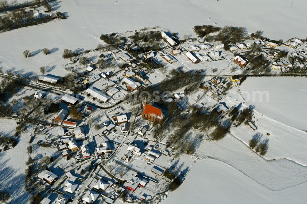 Kenz from the bird's eye view: Wintry snowy agricultural land and field boundaries surround the settlement area of the village on street Kastanienallee in Kenz in the state Mecklenburg - Western Pomerania, Germany