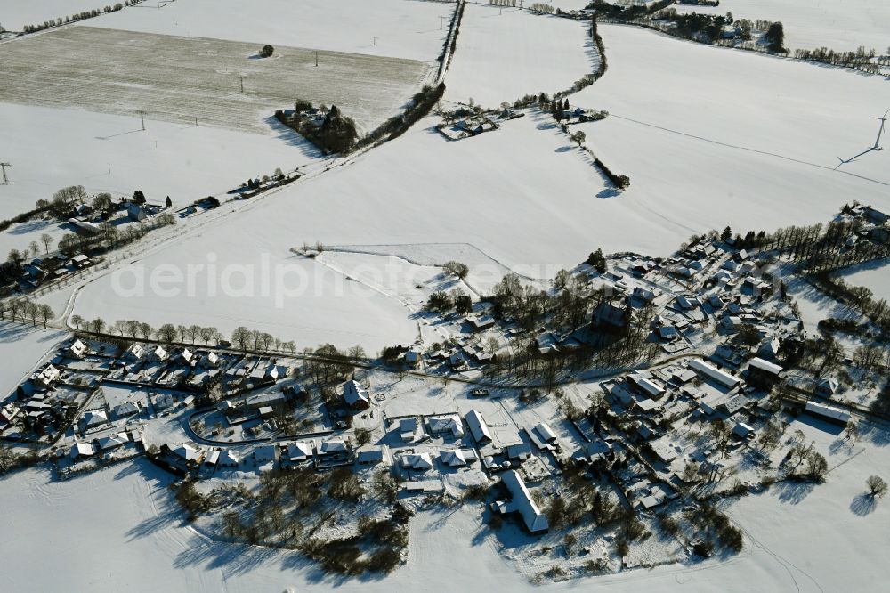 Kenz from the bird's eye view: Wintry snowy agricultural land and field boundaries surround the settlement area of the village on street Kastanienallee in Kenz in the state Mecklenburg - Western Pomerania, Germany