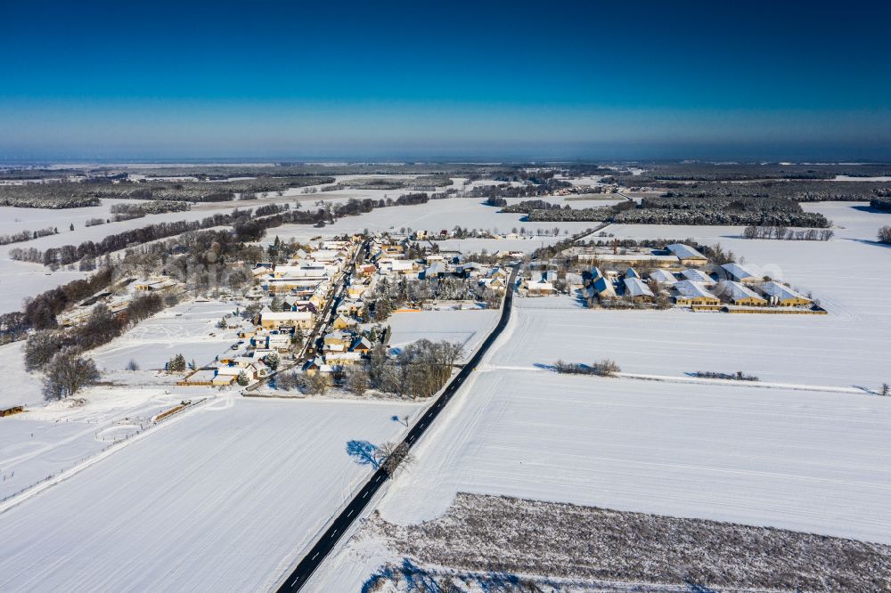 Aerial image Locktow - Wintry snowy agricultural land and field boundaries surround the settlement area of the village on street Hauptstrasse in Locktow in the state Brandenburg, Germany