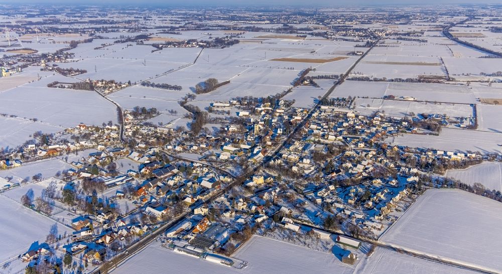 Ostönnen from the bird's eye view: Wintry snowy agricultural land and field boundaries surround the settlement area of the village in Ostoennen at Ruhrgebiet in the state North Rhine-Westphalia, Germany