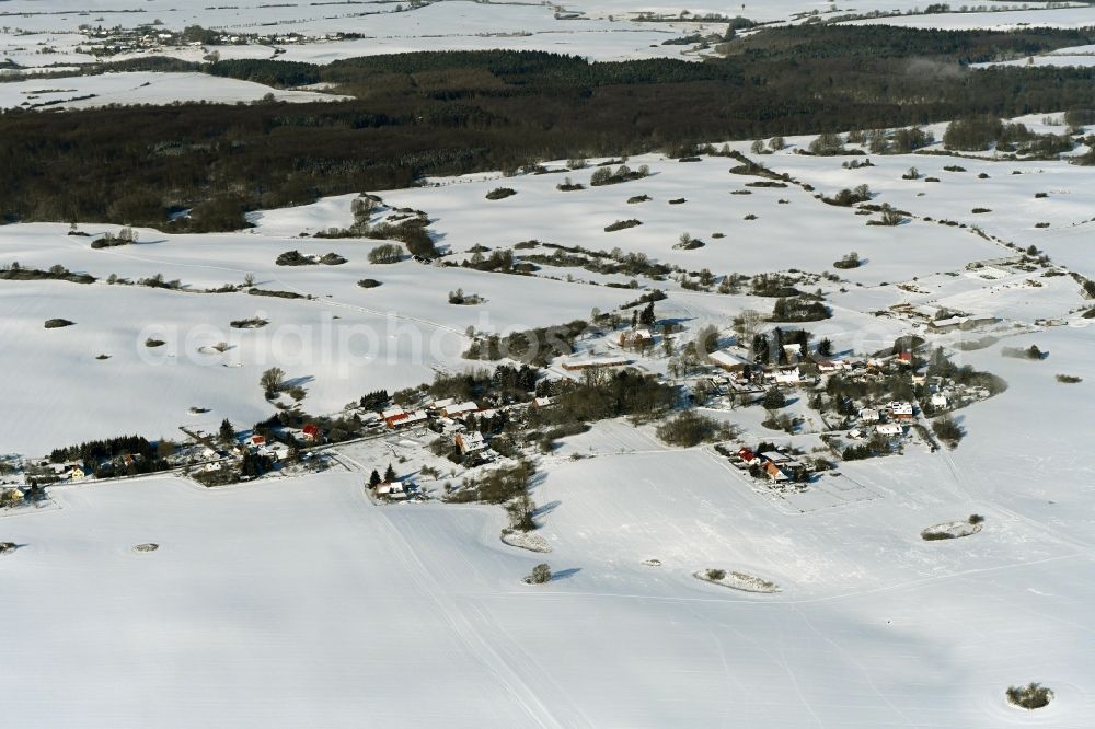 Aerial photograph Schlicht - Wintry snowy agricultural land and field boundaries surround the settlement area of the village in Schlicht in the state Mecklenburg - Western Pomerania, Germany
