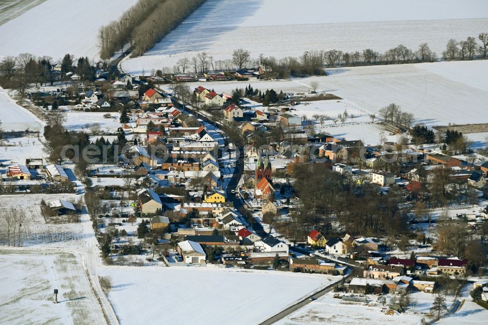 Aerial photograph Willmersdorf - Wintry snowy agricultural land and field boundaries surround the settlement area of the village in Willmersdorf in the state Brandenburg, Germany