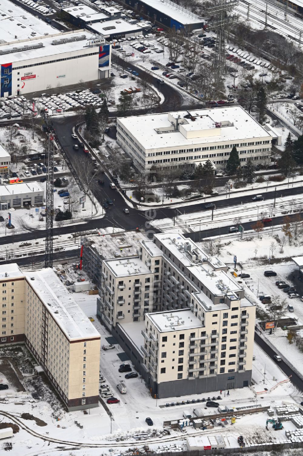 Aerial photograph Berlin - Wintry snowy construction site for the new residential and commercial Corner house - building on Marzahner Chaussee Ecke Allee of Kosmonauten in the district Marzahn in Berlin, Germany