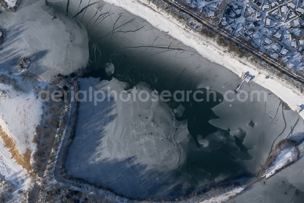 Aerial photograph Dankern - Wintry snowy strollers and passers-by walk on the ice sheet of the frozen bank areas of the lake - surface of Dankernsee in Dankern in the state Lower Saxony, Germany