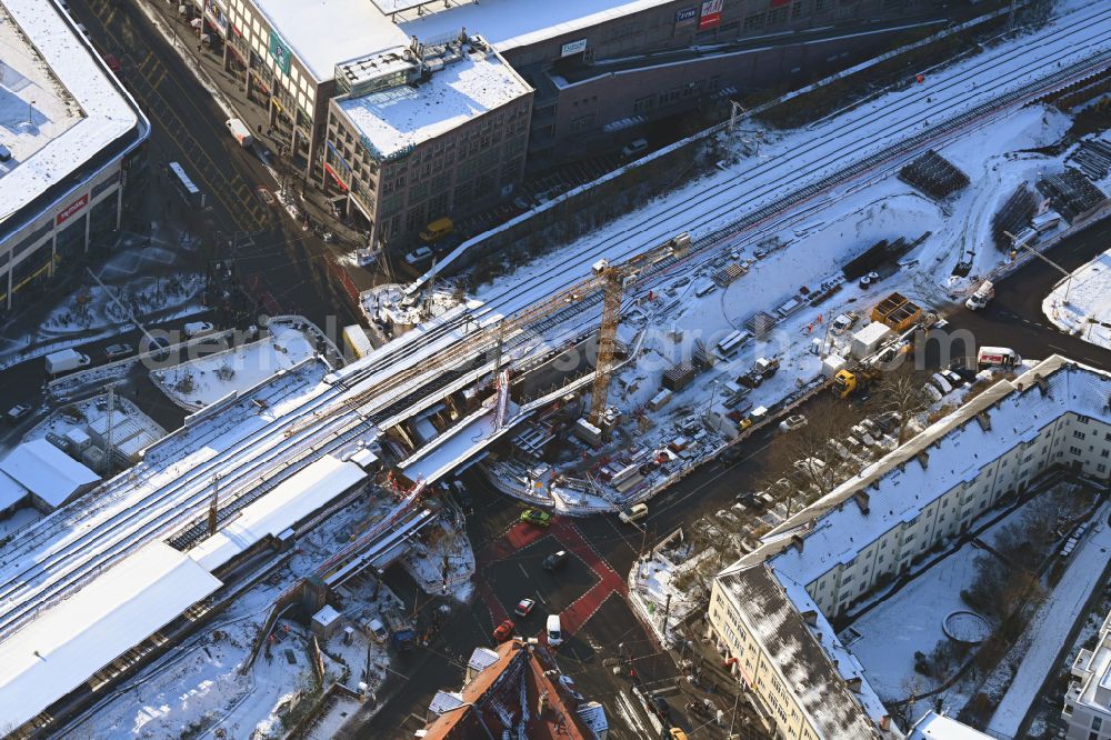 Aerial image Berlin - Wintry snowy construction site for the assembly of the replacement railway bridge structure for the routing of the railway tracks at the train station on place Elcknerplatz - Bahnhofstrasse - Am Bahndamm in the district Koepenick in Berlin, Germany