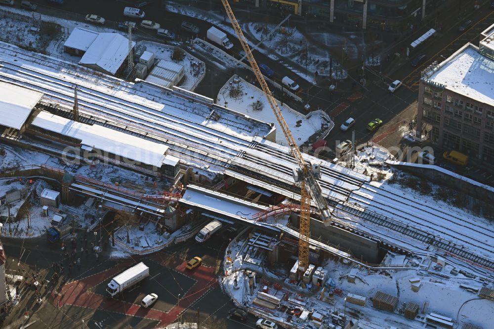 Aerial photograph Berlin - Wintry snowy construction site for the assembly of the replacement railway bridge structure for the routing of the railway tracks at the train station on place Elcknerplatz - Bahnhofstrasse - Am Bahndamm in the district Koepenick in Berlin, Germany