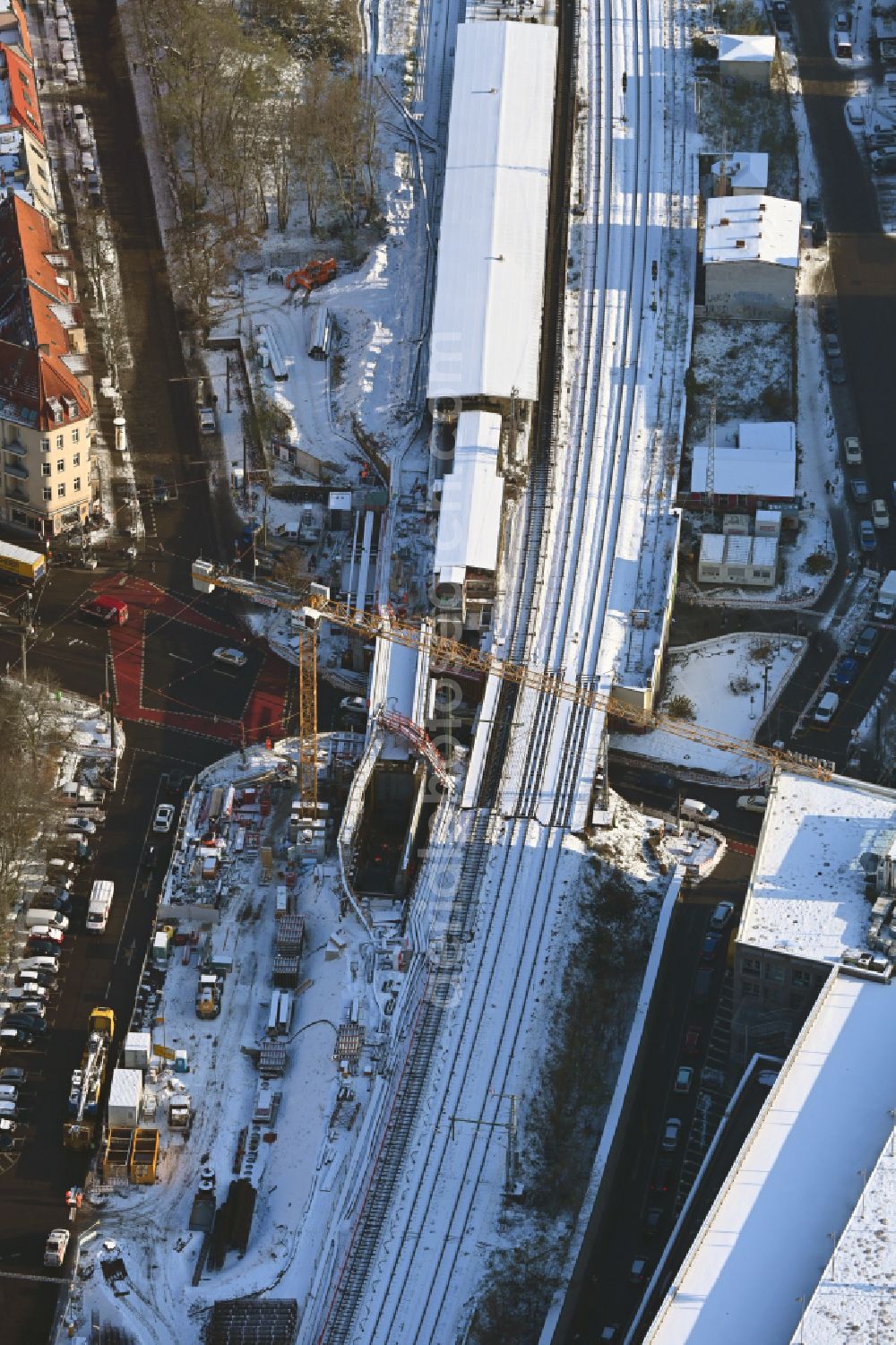 Berlin from above - Wintry snowy construction site for the assembly of the replacement railway bridge structure for the routing of the railway tracks at the train station on place Elcknerplatz - Bahnhofstrasse - Am Bahndamm in the district Koepenick in Berlin, Germany