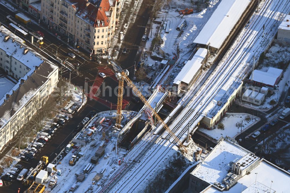 Berlin from the bird's eye view: Wintry snowy construction site for the assembly of the replacement railway bridge structure for the routing of the railway tracks at the train station on place Elcknerplatz - Bahnhofstrasse - Am Bahndamm in the district Koepenick in Berlin, Germany