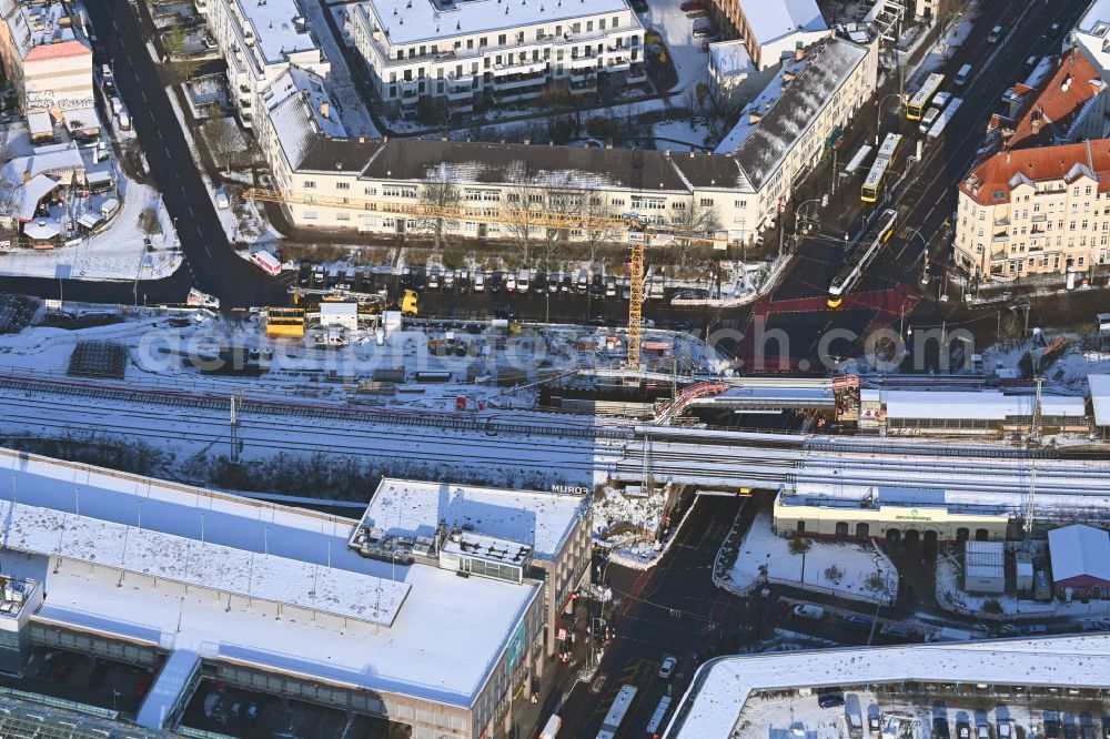 Aerial photograph Berlin - Wintry snowy construction site for the assembly of the replacement railway bridge structure for the routing of the railway tracks at the train station on place Elcknerplatz - Bahnhofstrasse - Am Bahndamm in the district Koepenick in Berlin, Germany