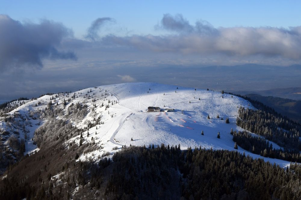 Aerial image Kleines Wiesental - Wintry snowy forest and mountain scenery in the Black Forest with the snow covered summit of Belchen in Kleines Wiesental in the state Baden-Wurttemberg, Germany