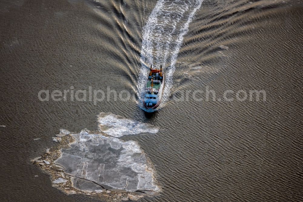 Juist from the bird's eye view: Winter aerial view Journey of a ferry ship Frisia X between floating ice floes in front of the North Sea island of Juist in the state of Lower Saxony, Germany